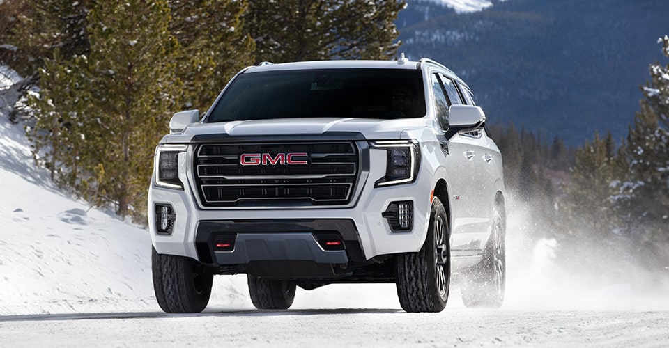 VUS pleine grandeur GMC Yukon 2024 stationné devant une maison moderne.