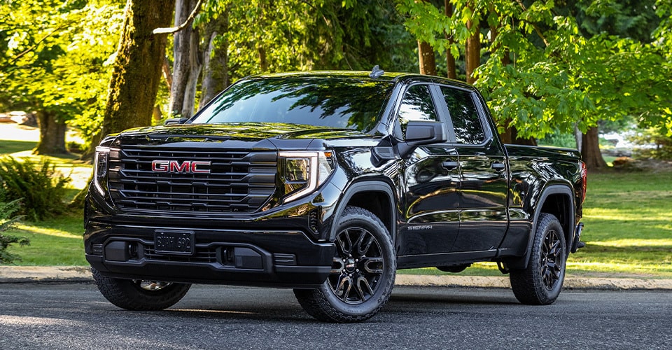 Vue latérale avant du pick-up pleine grandeur GMC Sierra 1500 2024 stationné sur la route.