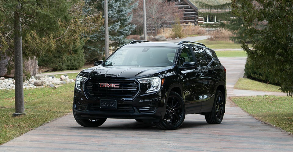  Vue latérale avant du GMC Terrain 2026 stationné à l’extérieur sous un ciel gris.