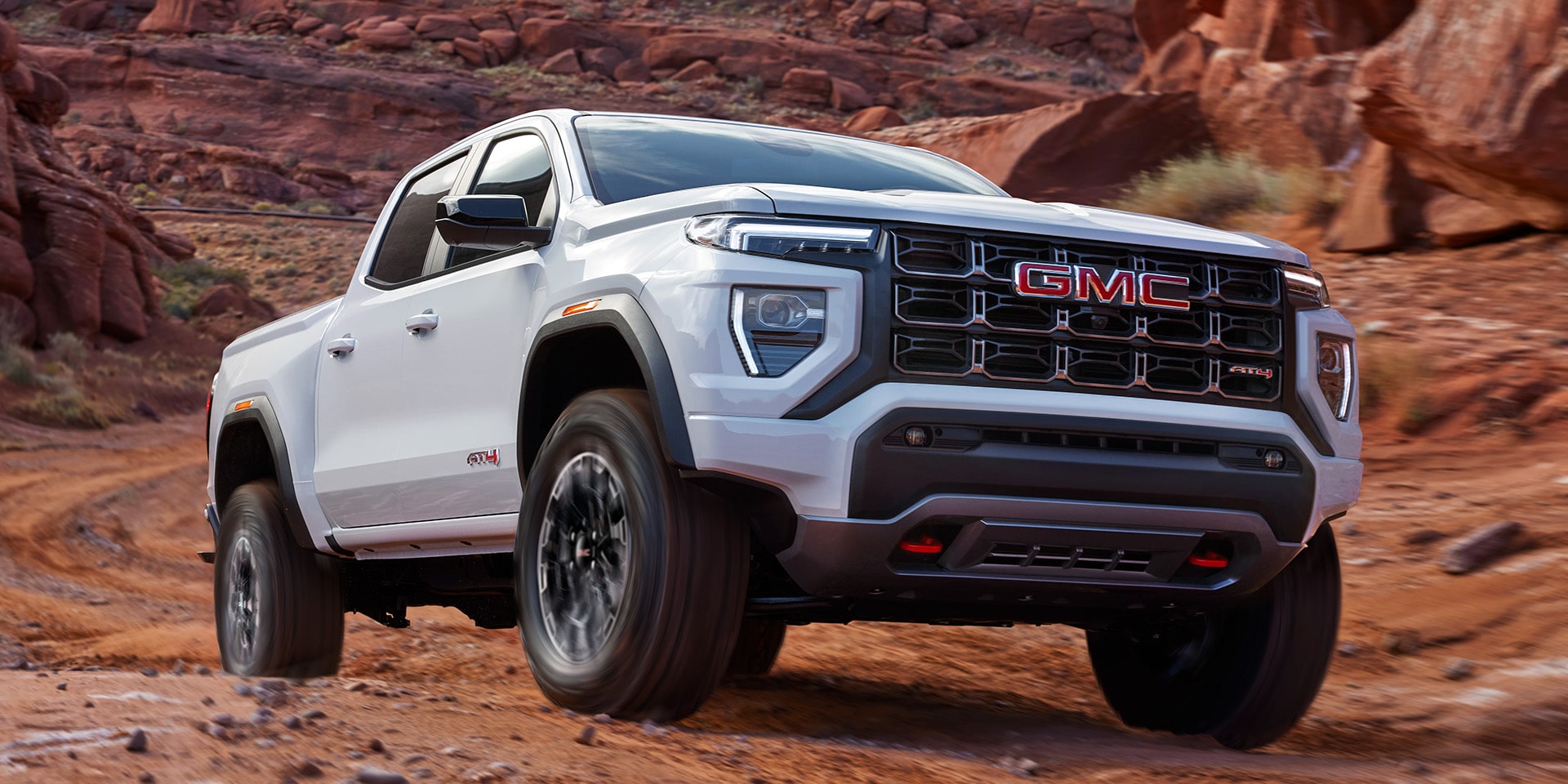 Exterior Front Three-Quarters View of the 2026 GMC Canyon Mid-Size Truck Parked in the Desert.