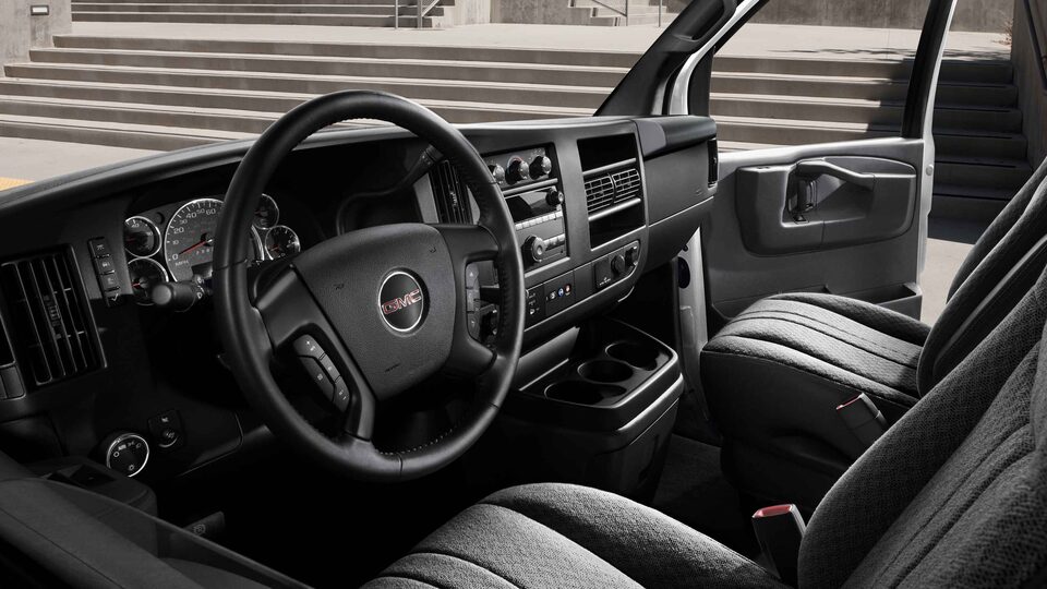La fourgonnette utilitaire GMC Savana 2023 avec tableau de bord, volant et commandes.