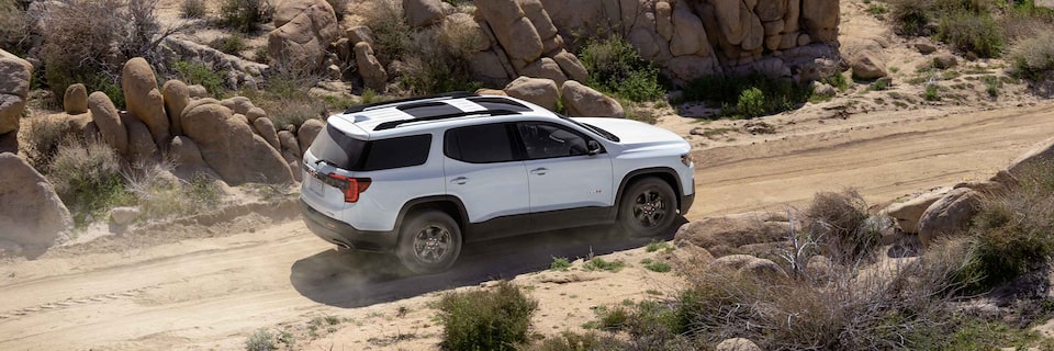 Vue latérale d'un GMC Acadia AT4 2021 en conduite tout-terrain.