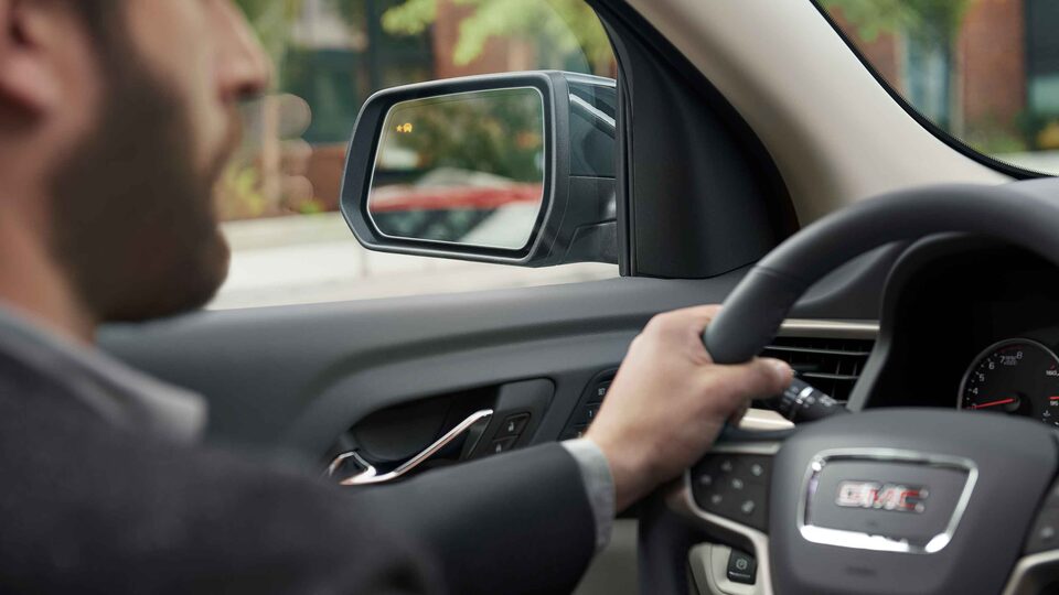 Un homme au volant d’un GMC Acadia 2023.