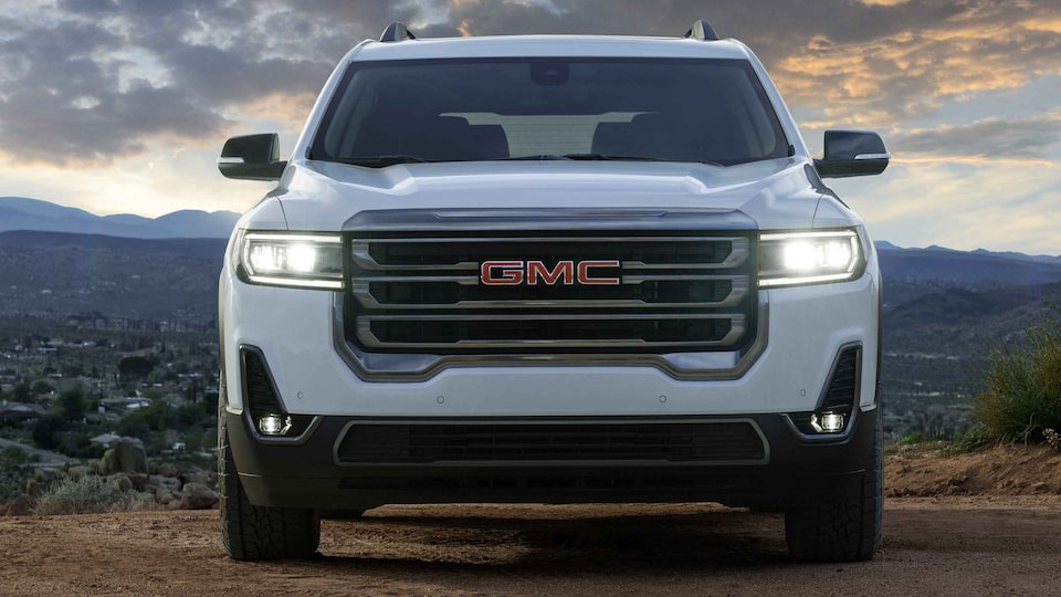 Vue avant du GMC Acadia AT4 2023 avec les phares allumés.
