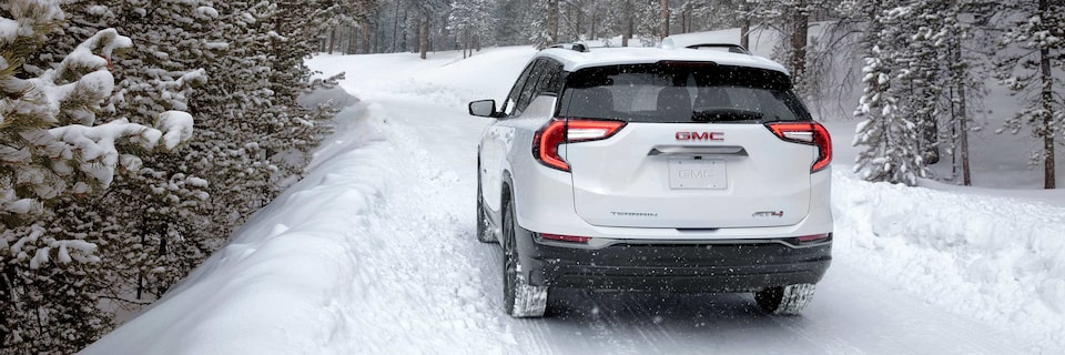Vue arrière du GMC Terrain AT4 2023 sur une route enneigée.