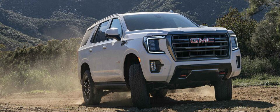 Front view of the 2023 GMC Yukon AT4 driving off-road.