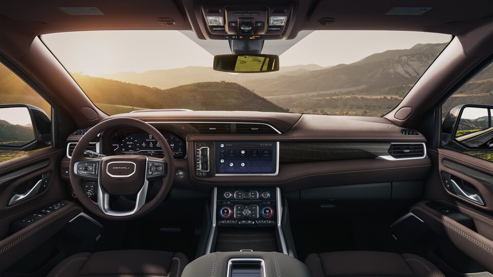 Habitacle côté conducteur, volant chauffant et console centrale à porte-gobelets du GMC Yukon Denali 2023.