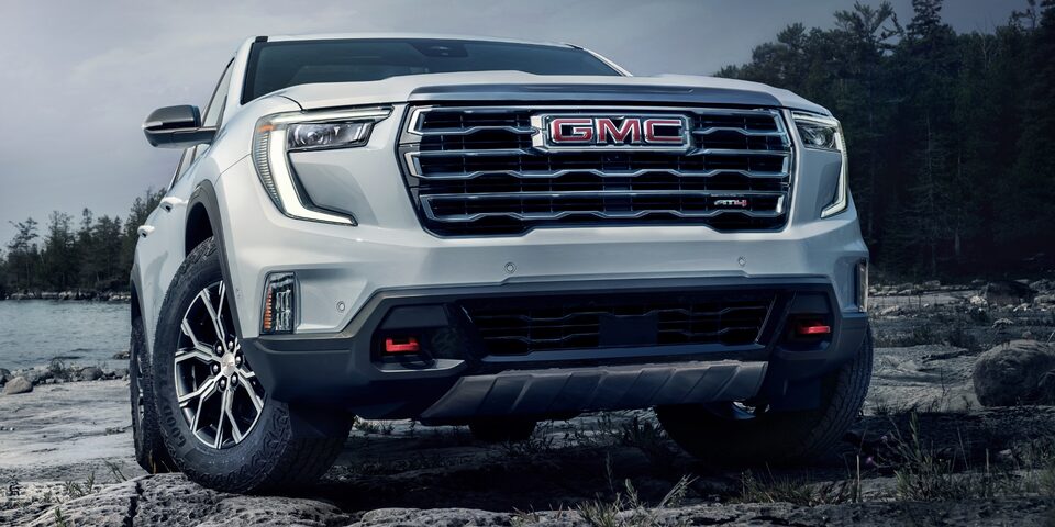 Vue latérale en contre-plongée du GMC Acadia AT4 2024 stationné à la plage.