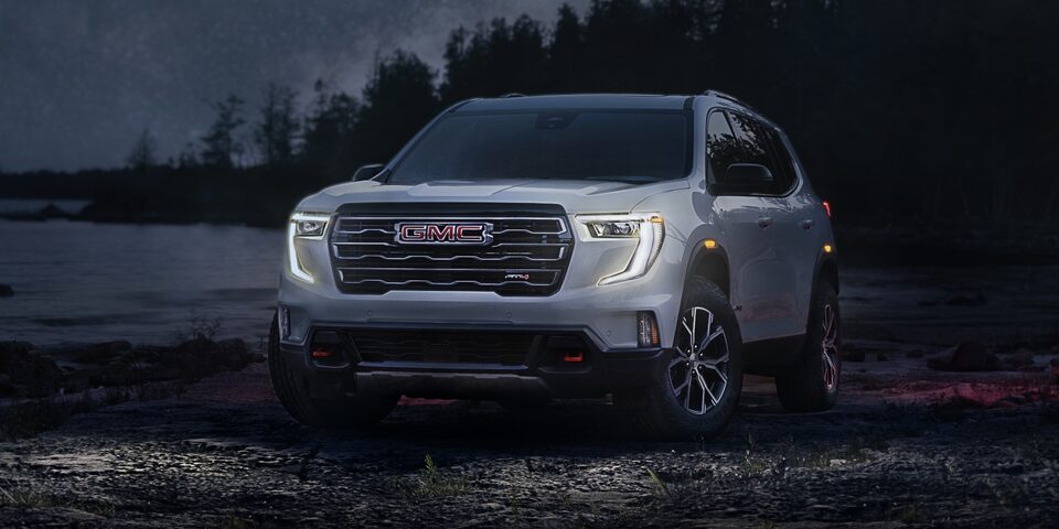 Vue latérale avant du GMC Acadia AT4 2024 avec la calandre et l’emblème uniques.