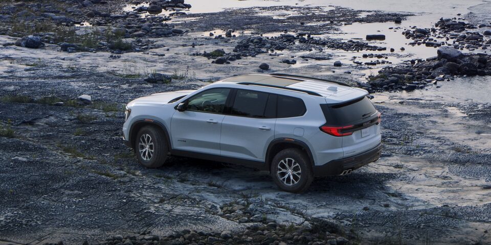  GMC Acadia AT4 2024 stationné seul sur un terrain rocailleux.