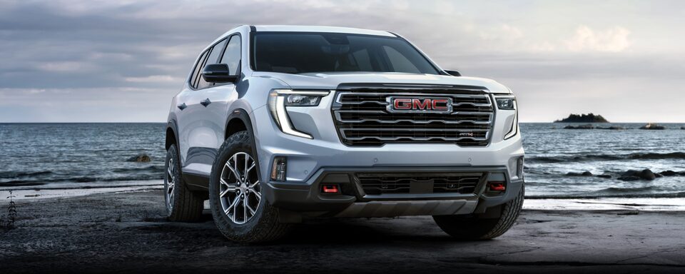Vue latérale avant du GMC Acadia AT4 2024 stationné à la plage.