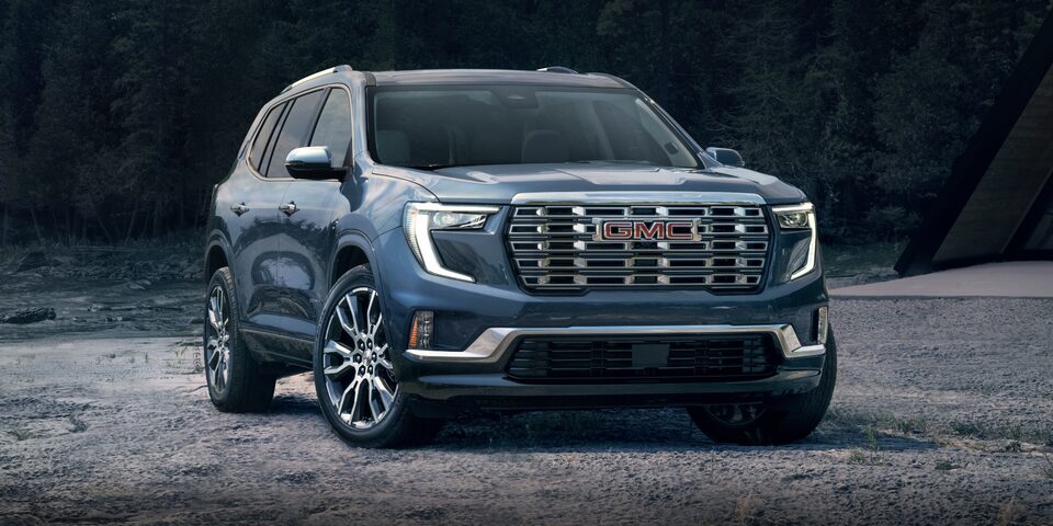 Vue latérale avant du GMC Acadia Denali 2024 avec la calandre et l’emblème uniques.