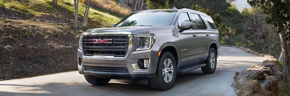 2024 GMC Yukon SLE/ SLT driving alone on the road.