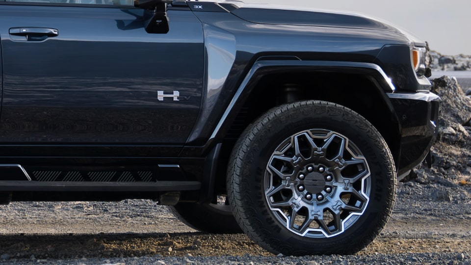 Vue latérale rapprochée de la portière et des évasements de cages de roue du côté passager du camion GMC Hummer EV 2025.