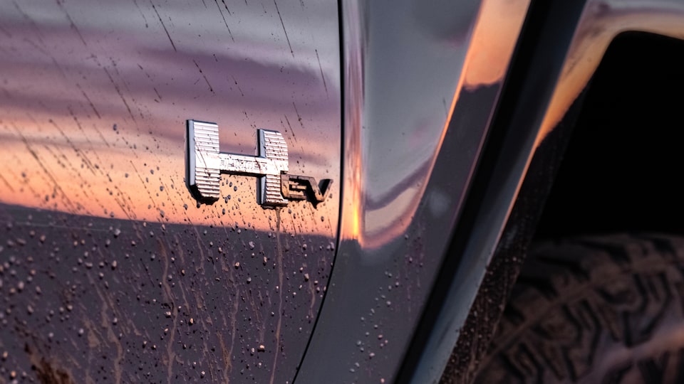 Vue rapprochée de l’emblème sur l’extérieur du GMC Hummer EV 2025 couvert de boue.