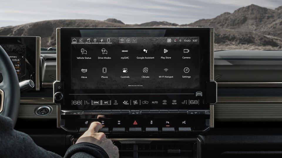 Vue rapprochée d’une personne qui choisit une option sur l’écran haute définition du camion GMC Hummer EV 2025.