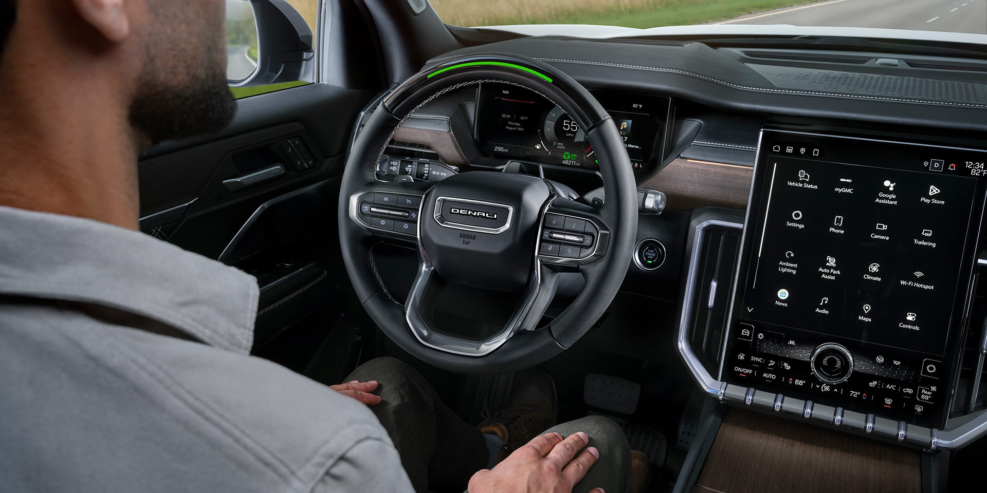 Un homme assis au volant d’un VUS GMC Acadia 2027, les mains sur les genoux, utilisant la fonction Super Cruise.