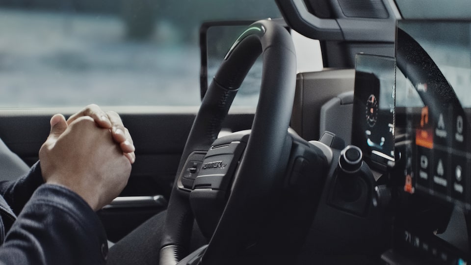  GMC Hummer EV Pickup steering wheel while the Available Super Cruise system is in use, allowing for a hands-free driving experience.