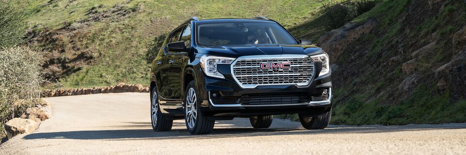 The 2024 GMC Terrain Denali driving on the road.