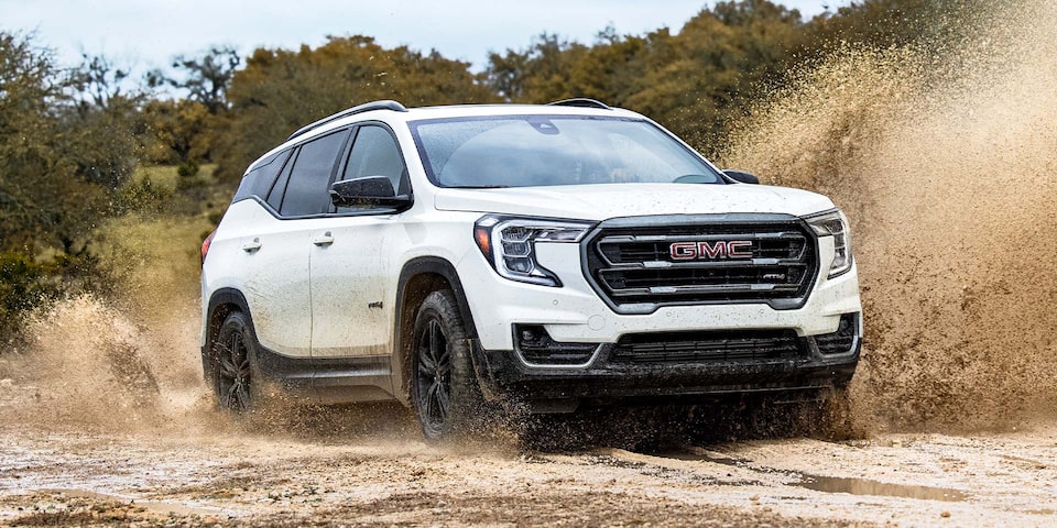 2024 GMC Terrain AT4 driving through sandy terrain.
