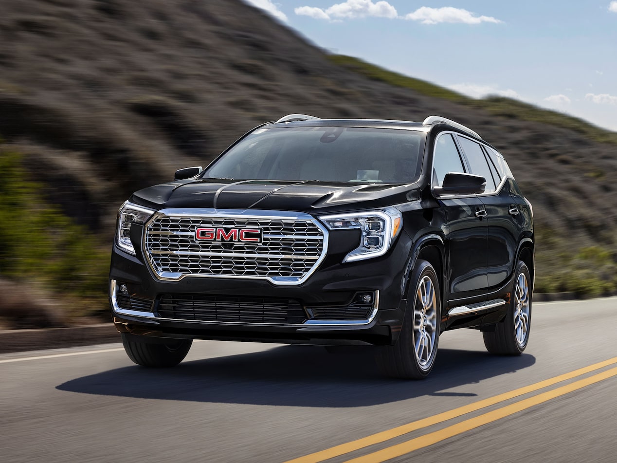 Front-side view of the 2025 GMC Terrain driving alone on a countryside road.