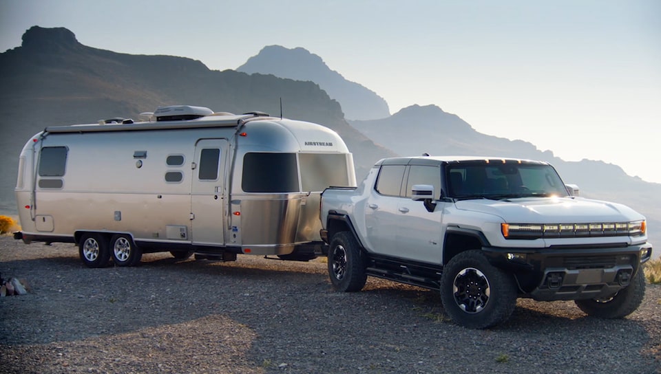 GMC Hummer EV with a trailer behind it.