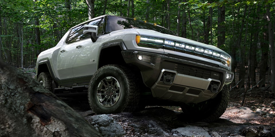 GMC Hummer EV en mouvement dans une forêt.