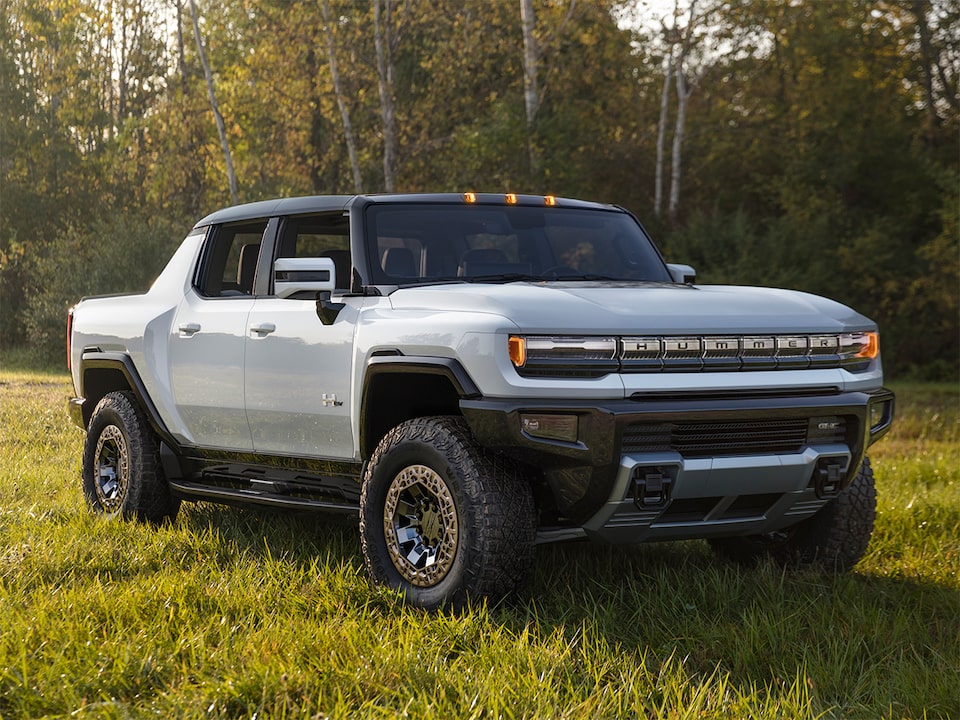 GMC Hummer EV en mouvement sur de l’herbe.