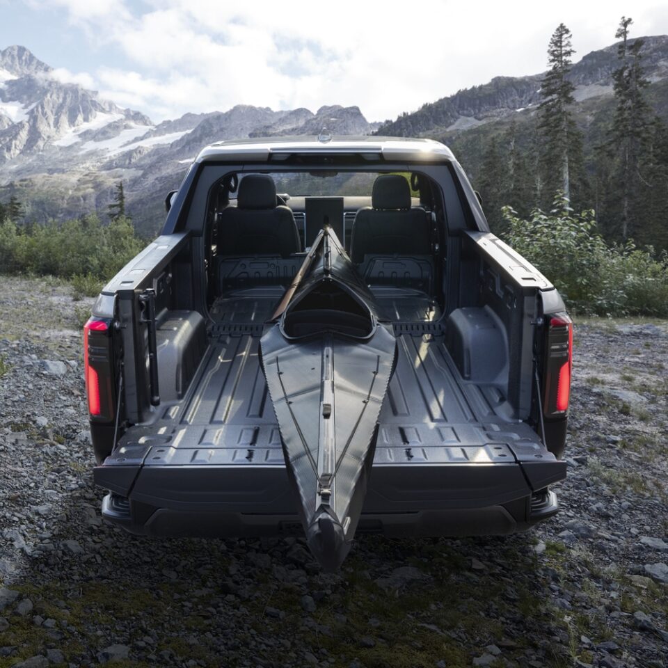 Vue arrière du GMC Sierra EV Denali édition 1 qui transporte un kayak dans sa caisse.