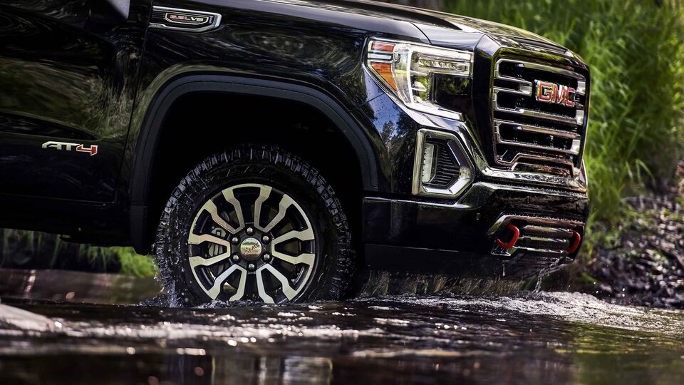 2022 GMC Sierra 1500 AT4 driving through terrain.