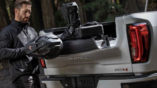 Homme utilisant la caisse du GMC Sierra HD AT4 2022.