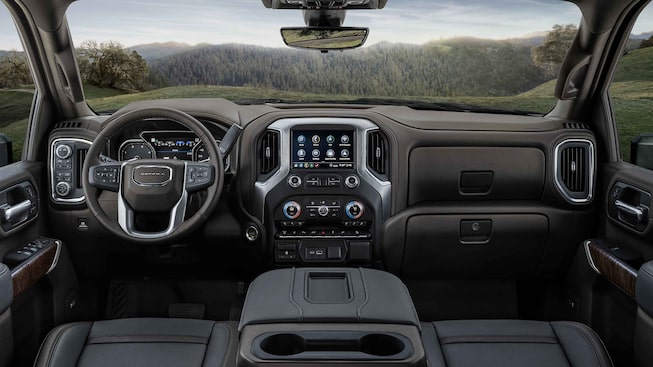 2022 GMC Sierra HD Denali front interior featuring the dashboard, steering wheel, and infotainment system.