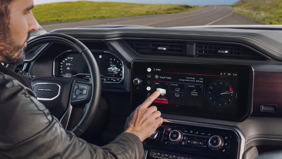 A person operating the touch screen on the 2022 Sierra 1500 Denali Ultimate.