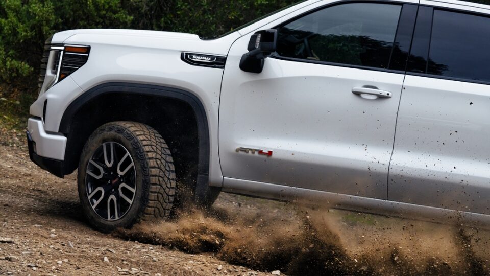 Exterior driver-side view of the 2022 Sierra 1500 AT4 driving off-road.