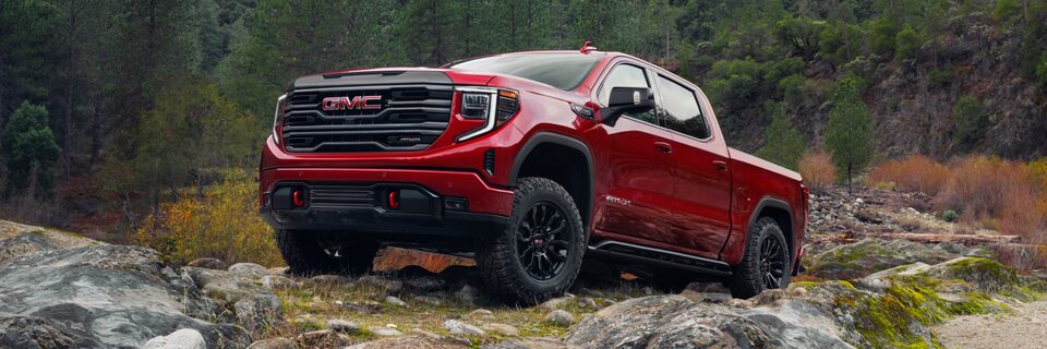 The 2022 Sierra 1500 AT4X driving over rocky terrain.