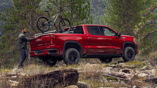 An owner loads up their bike into the GMC Sierra AT4 truck bed.