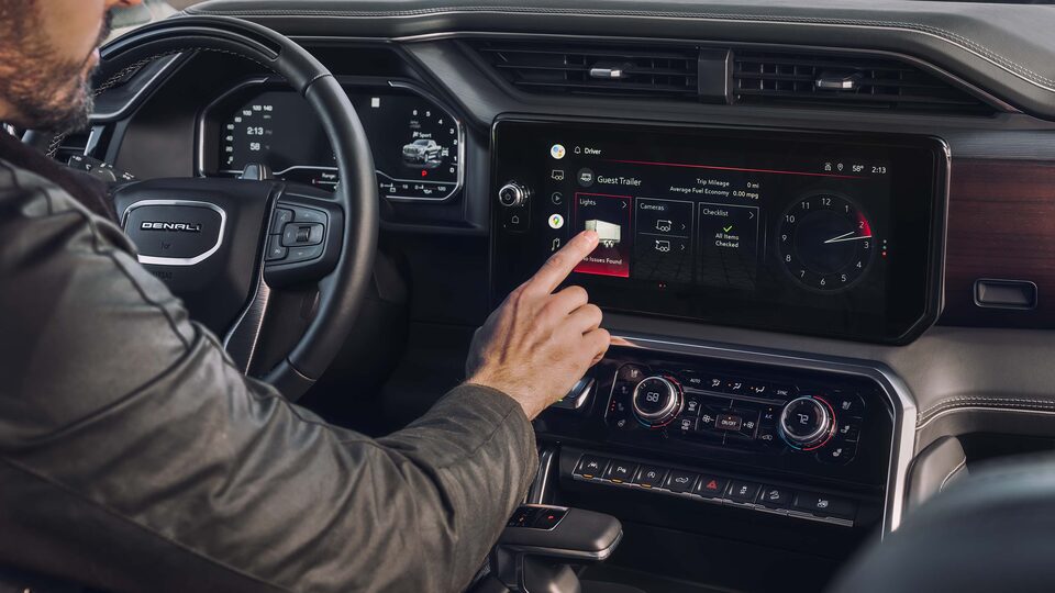 A person operating the touch screen on the 2023 Sierra 1500 Denali Ultimate.
