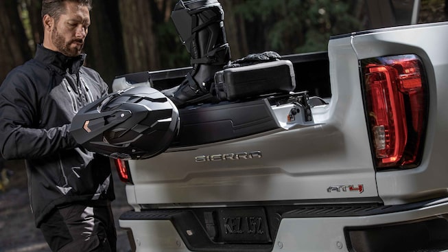 Homme utilisant la caisse du GMC Sierra HD AT4 2023.