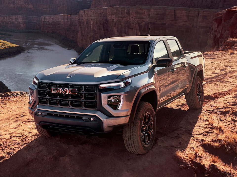 Front-side view of the 2025 Canyon driving in a canyon landscape.