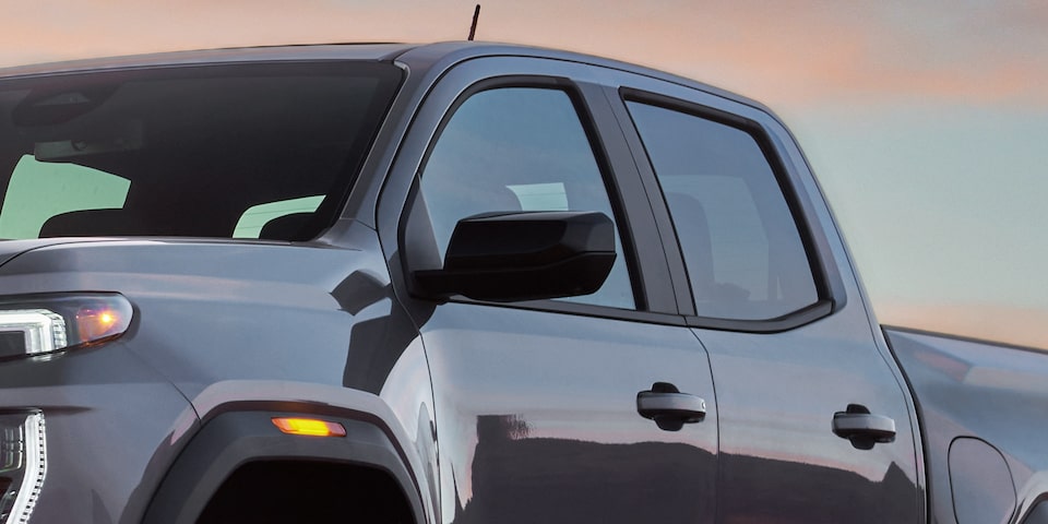 Vue rapprochée de l’extérieur côté conducteur et d’un rétroviseur du GMC Canyon 2025.