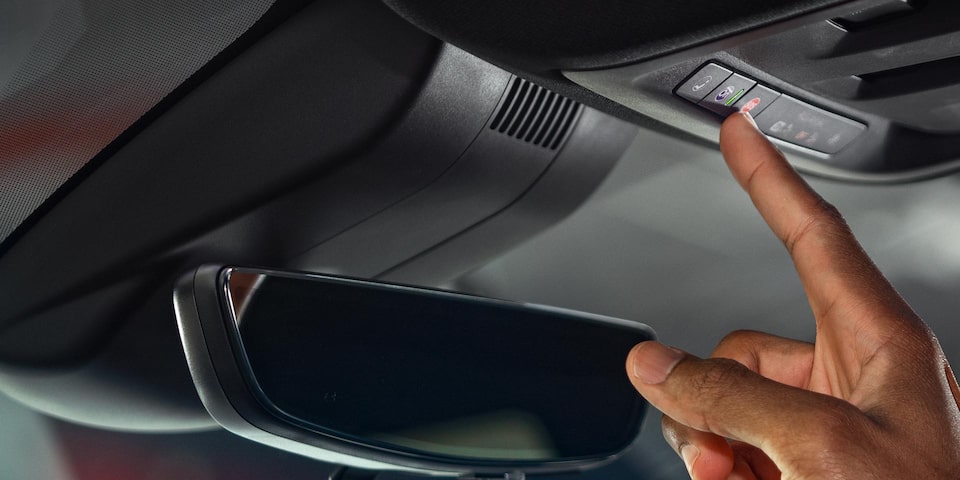Vue rapprochée d’une personne qui appuie sur le bouton OnStar du GMC Canyon 2025.
