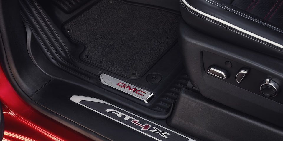 Vue rapprochée du seuil de porte avec emblème AT4X du camion GMC Sierra HD AT4 2025.