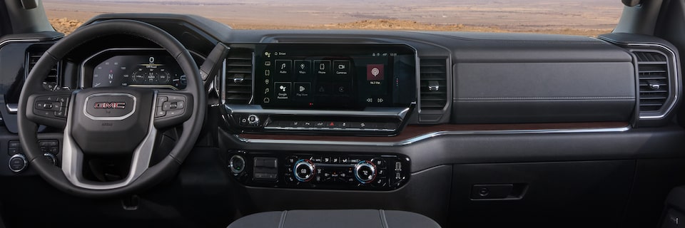 Wide View of the Dashboard, Infotainment System, and Steering Wheel inside the 2025 GMC Sierra HD Pro/SLE/SLT Truck.