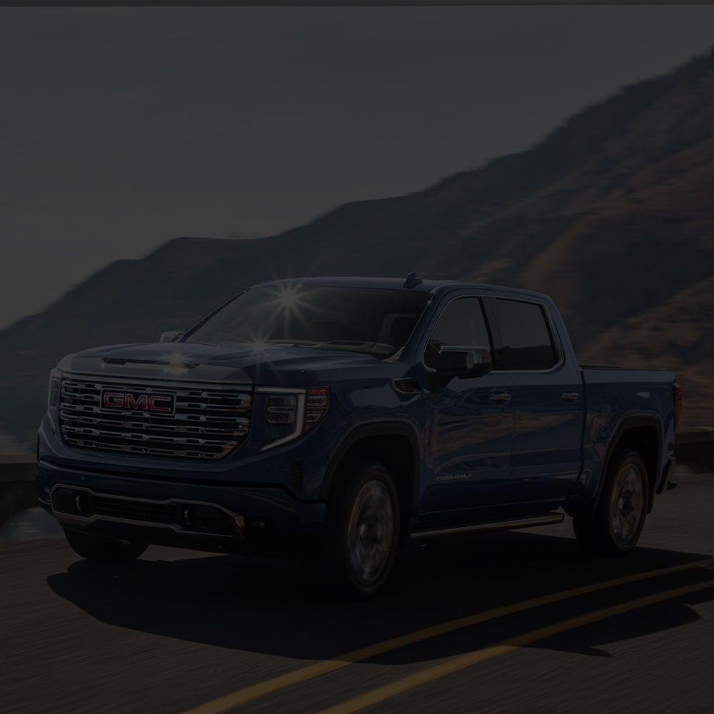  Le GMC Sierra 1500 2026 en mouvement sur une route côtière.
