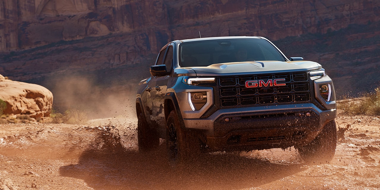 Front view of the 2026 GMC Canyon skidding on a dusty terrain.
