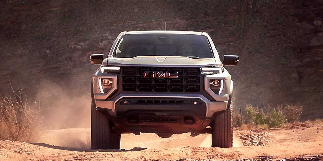 Front view of the 2026 GMC Canyon Elevation skidding on a dusty terrain.