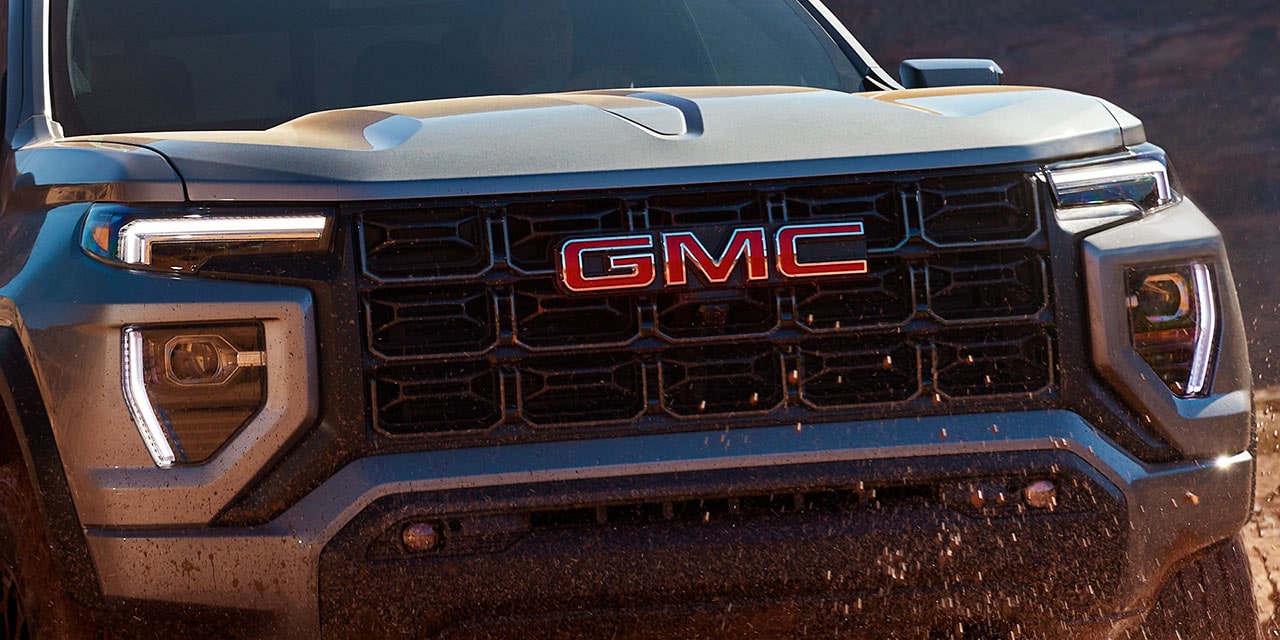 Close up view of the 2026 GMC Canyon Elevation with its LED headlamps turned on.