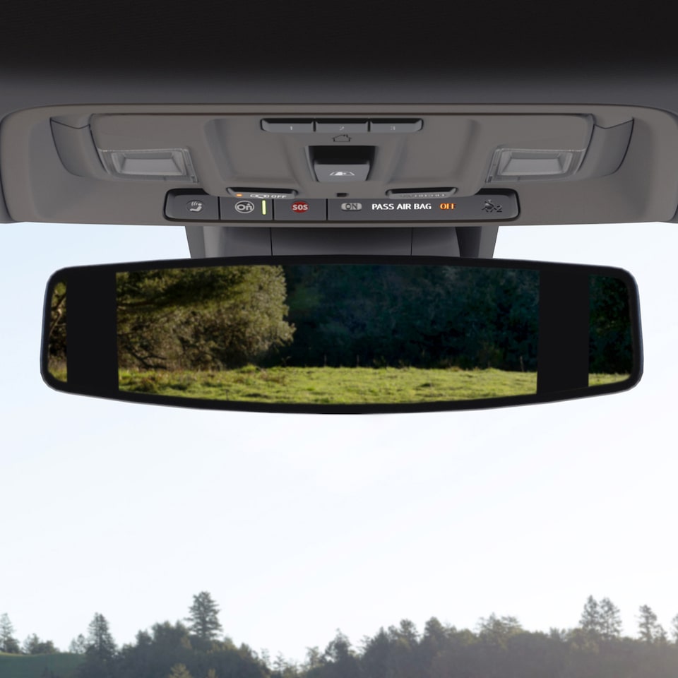 Un pré reflété dans le rétroviseur du GMC Sierra 1500 2024.