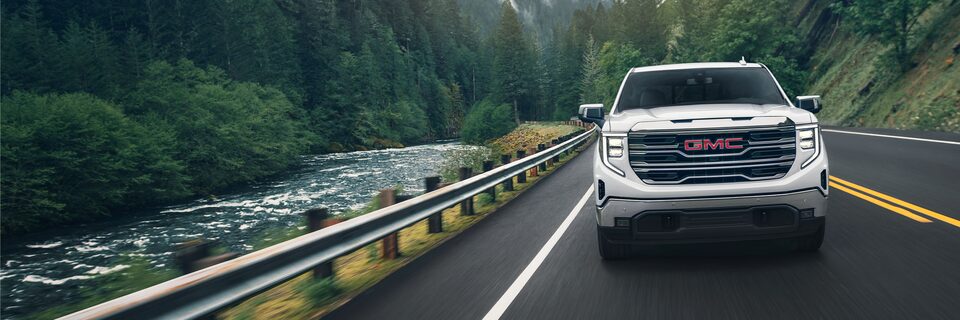 The 2024 GMC Sierra 1500 SLE driving on a road