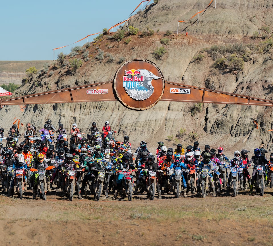 A biker performing a stunt to a crowd at a Red Bull Joyride event.